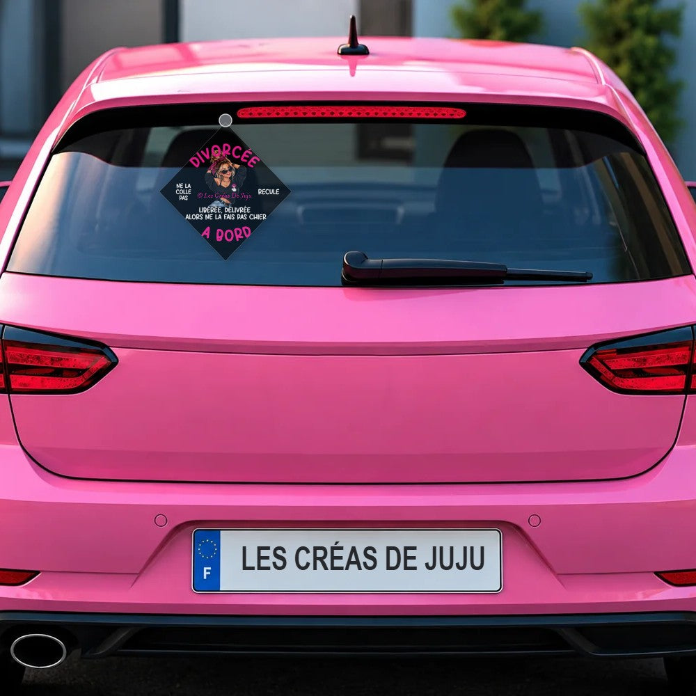 Plaque ventouse Divorcée à bord fond noir derrière la lunette arrière d'une voiture rose