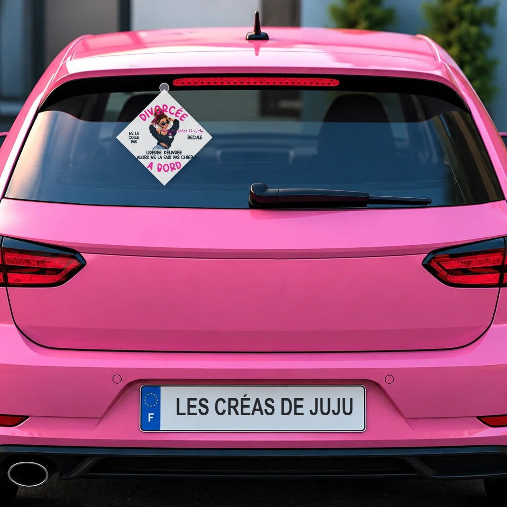 Plaque ventouse Divorcée à bord fond blanc derrière la lunette arrière d'une voiture rose